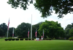 A park setting with flags at half-staff honoring Bruce Host